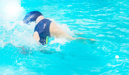 Two female swimmers simultaneously dive in an outdoor pool, demonstrating their skill, Sunny summer...
