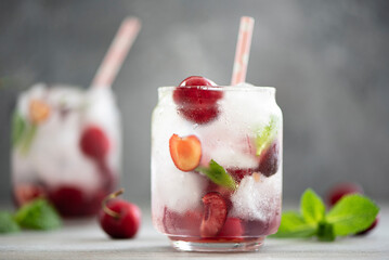 summer cocktail with cherries, mint and ice