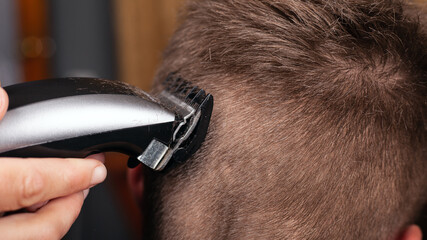 cutting hair with a trimmer, barbershop men's haircut