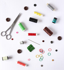 Fototapeta na wymiar scissors, threads, needles and buttons on a white background
