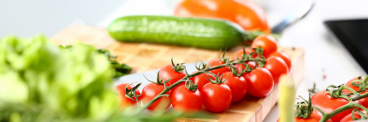 Organic Healthy Vegetable Ingredient Assortment. Small Tomato Cherry and Cucumber on Wooden Cutting Board. Green Aromatic Lettuce. Dieting Salad Food in Kitchen Horizontal Photography