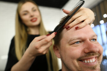 Barber Hairstylist Making Haircut for Man Client. Woman Hairdresser Combing Happy and Smiling Guy. Beautician with Hairbrush for Male Hairdo. Bearded Person Sitting in Professional Beauty Studio