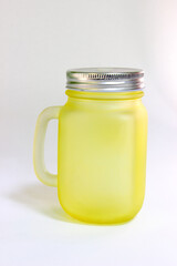 Yellow glass mug with lid and hole for straws for smoothies and drinks