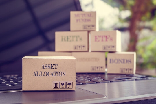 Online asset allocation / portfolio risk diversification for long-term sustainable growth concept : Boxes of financial products e.g asset allocation, bond, commodities, stocks, ETFs, REITs on a laptop