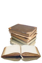 Open book and stack of old vintage books reflecting on a white surface