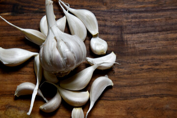 garlic and garlic cloves on wooden chopping board