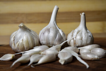 garlic and garlic cloves on wooden chopping board