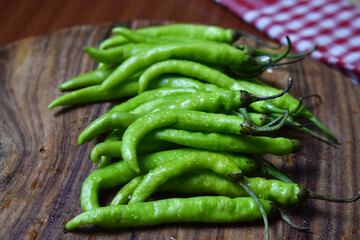 fresh green chilies on chopping board for spicy vegetable 