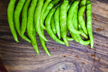 fresh green chilies on chopping board for spicy vegetable 