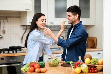 Lovely couple preparing dinner and feeding each other