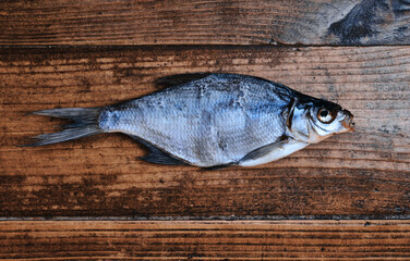 Salty dry river fish on a dark wooden background. Dry fish in the market. Street food.
