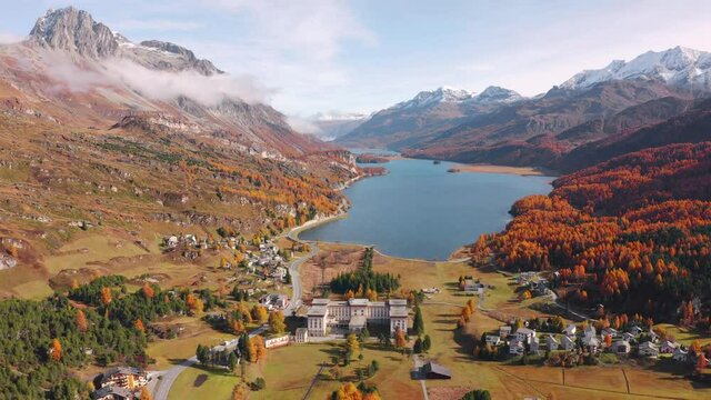 4k drone flight moving to the side footage (Ultra High Definition). Attractive autumn view of Sils lake. Spectacular morning scene of Swiss Alps, Maloya village, Switzerland, Europe.