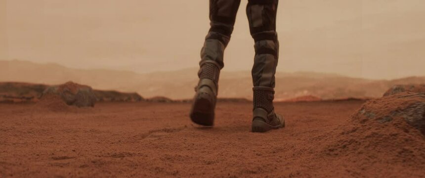 CU astronaut walking towards a cliff while exploring Mars planet surface. Colonization concept. Shot on ARRI Alexa Mini