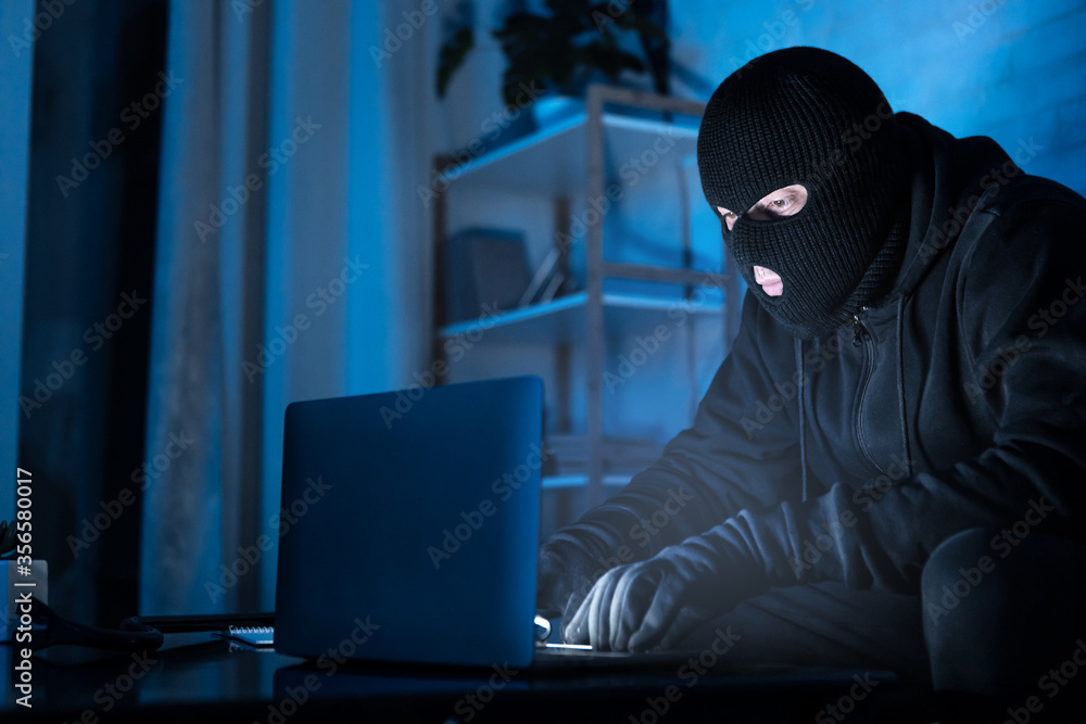 Poster Masked hacker downloading private information using pc