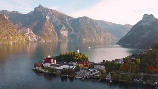4k drone forward video (Ultra High Definition).  Gorgeous morning view of Maria Kronung church. Aerial autumn scene of Traunsee with Traunstein peak on background, Austria, Europe.