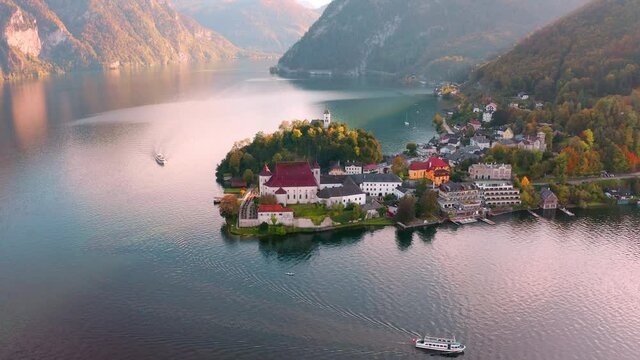 4k point of view video (Ultra High Definition). Picturesque morning scene of Maria Kronung church. Aerial autumn view of Traunsee lake. Stunnig landscape of Austrian Alps.