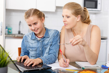 Fototapeta premium Girl and her mother doing home task