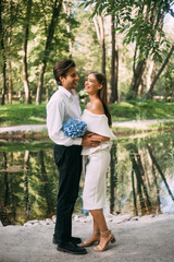Fototapeta premium Just married couple embracing standing near lake in park