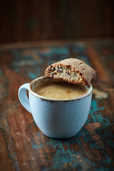 Cantuccini (Italian biscuits) with a cup of coffee on rustic wooden background. Close up.   