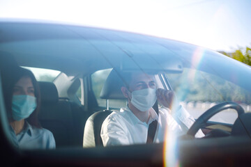 Fototapeta na wymiar Boy and girl in protective sterile medical mask in the car during an epidemic in quarantine city. Health protection, safety and pandemic concept. Covid - 19.
