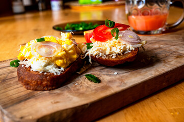 Wooden kitchen board with 2 toasts with fried eggs.