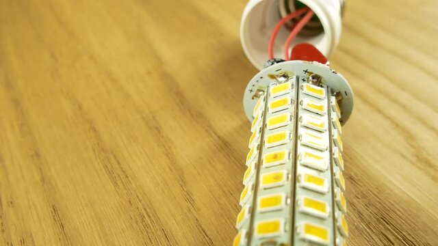 The disassembled LED corn lamp is on the table. Base E27