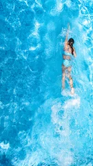 Fotobehang Active girl in swimming pool aerial drone view from above, young woman swims in blue water, tropical vacation, holiday on resort concept  © Iuliia Sokolovska