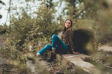 Portrait einer jungen Frau in Bluse und Jeans in einem Lost Place