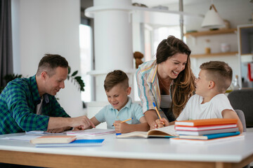 Parents helping the kids with their homework. Litlle boys learning at home.