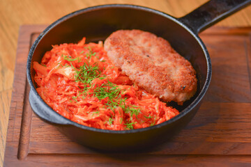 Fried chicken meat in frying pan with vegetable stew. Traditional Ukrainian cuisine, tasty dish. Delicious dinner.