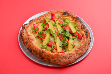 Close-up of a delicious smoked salmon pizza with cheese, avocado and smoked salmon. Sea-food. Bright red background.