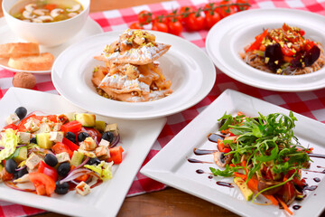 Different food, Italian dishes on the table. Vegetable and meat salad, pasta, soup and puff pastry dessert.