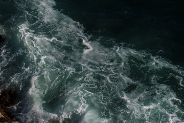 Naklejka na ściany i meble Ocean wave background breaking sea water rocky shore