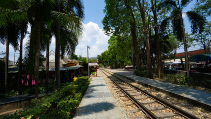 Kanchanaburi, Thailand - April 3, 2019:  Outdoor River Kwai Bridge train station in urban area with trees