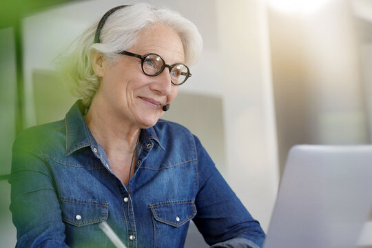 Active Senior Woman Working From Home On Laptop