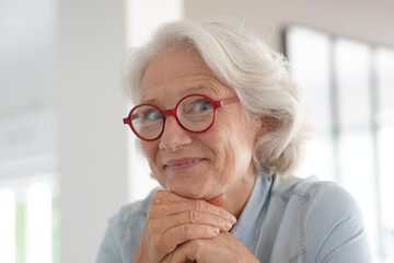 Smiling senior woman with red eyeglasses