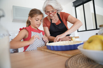 Grandmother with grandkid making apple pie
