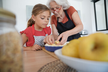 Grandmother with grandkid making apple pie