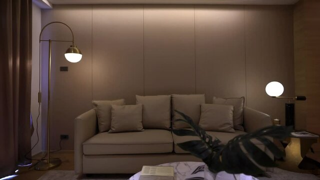 Footage of Stylish luxury living room with  beige leather sofa, gold stainless wall lamp and wallcovering in the background / luxury interior / copy space /