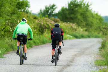 Fototapeta premium Two bikers with mountain bikes on a gravel road