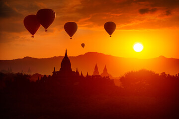 Enjoying colorful sunrise over of Buddhist stupas and hot air balloons in the ancient Bagan. Myanmar, Asia.