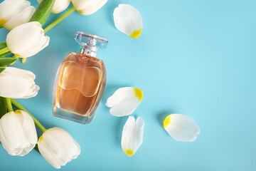 Beautiful perfume bottle and tender white tulips