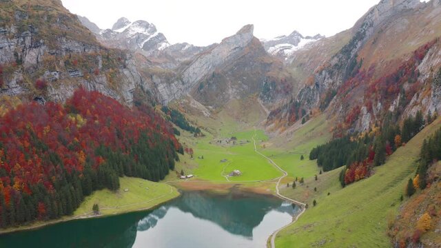 4k drone flight moving to the side footage (Ultra High Definition). Amazing morning view of Seealpsee lake. Breathtaking autumn scene of Swiss Alps. Santis peak reflected in the surface of water lake.