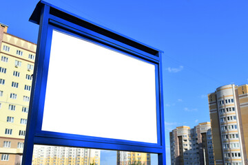 Obraz premium Billboard with white place for text or advertisement on the background of new multi-storey buildings