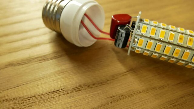 The disassembled LED corn lamp is on the table. Base E27