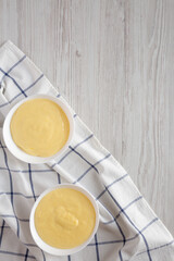 Homemade vanilla custard pudding in white bowls, top view. Flat lay, overhead, from above. Space for text.