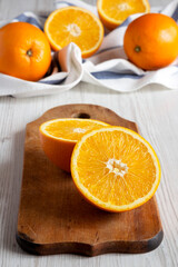 Halved oranges on a rustic wooden board, side view. Close-up.
