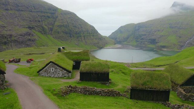 4k drone flight moving to the side footage (Ultra High Definition). Summer view of Saksun village with typical turf-top houses, Faroe Islands. Nice morning scene of Streymoy island, Denmark, Europe.