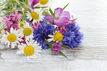 bunch of flowers from meadow flowers with cornflowers on wooden table