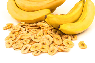 Heap of dried banana chips with yellow banana bunch